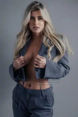 Very beautiful blonde girl opening her jacket buttons