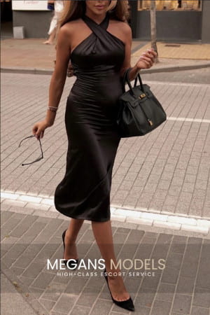 Elegant woman in a black dress walking down the street
