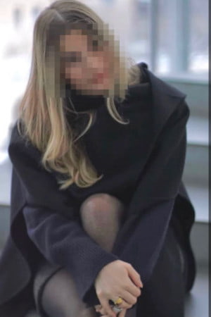 High class German girl in a grey winter coat with her face blurred